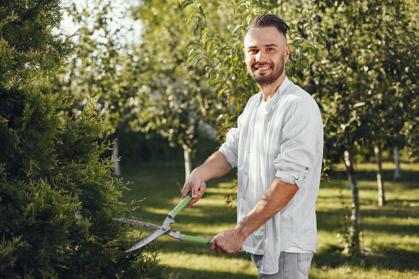 Smiling gardener pruning in a sunny Sydney garden
